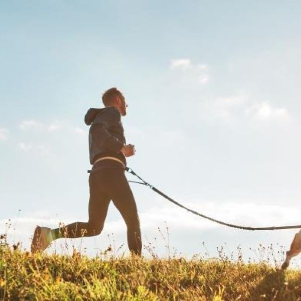 man running with dog as